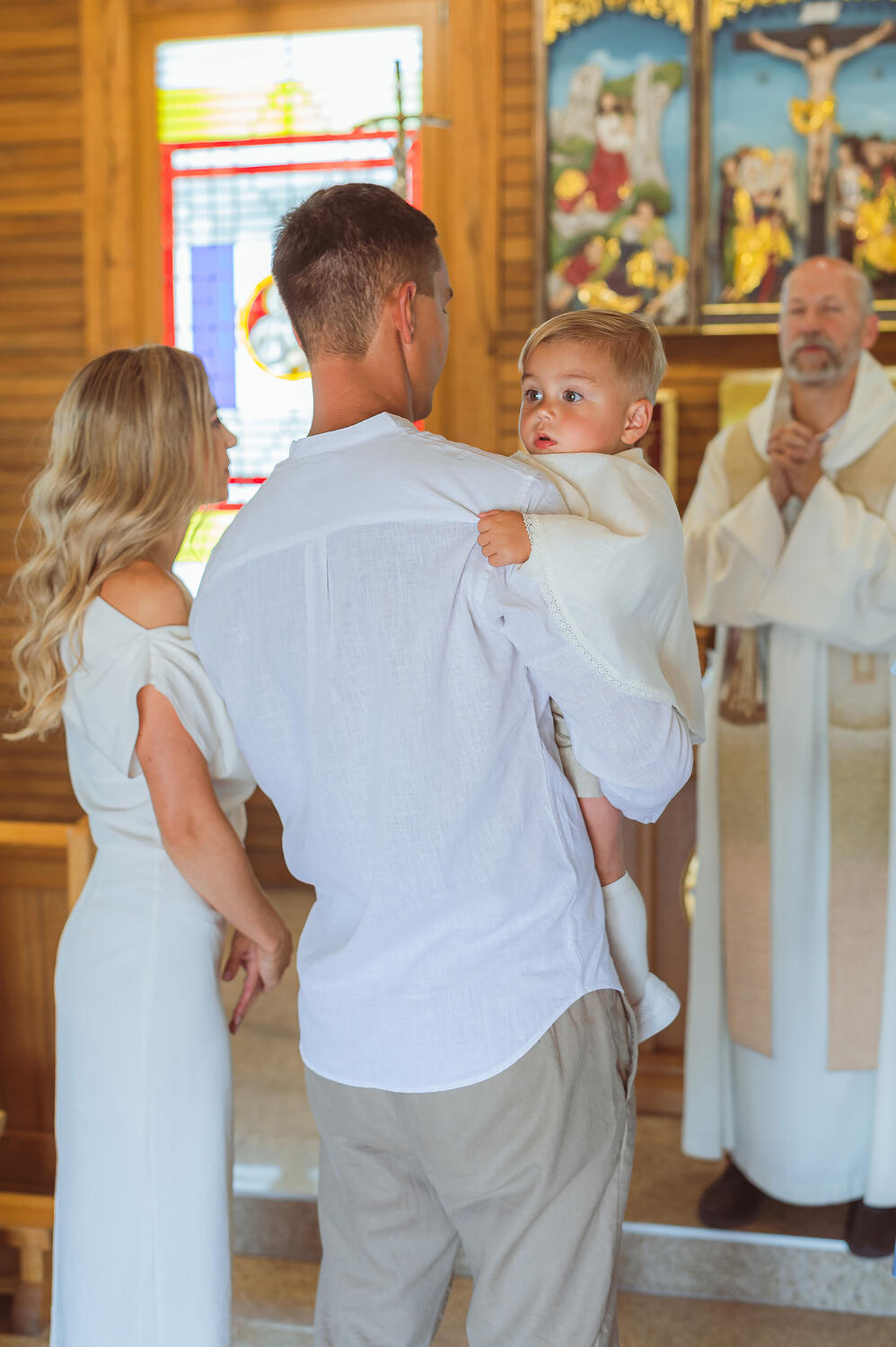 Mama, tėtis, sūnus Krikštynų fotografija – tėvai laiko mažylį ant rankų