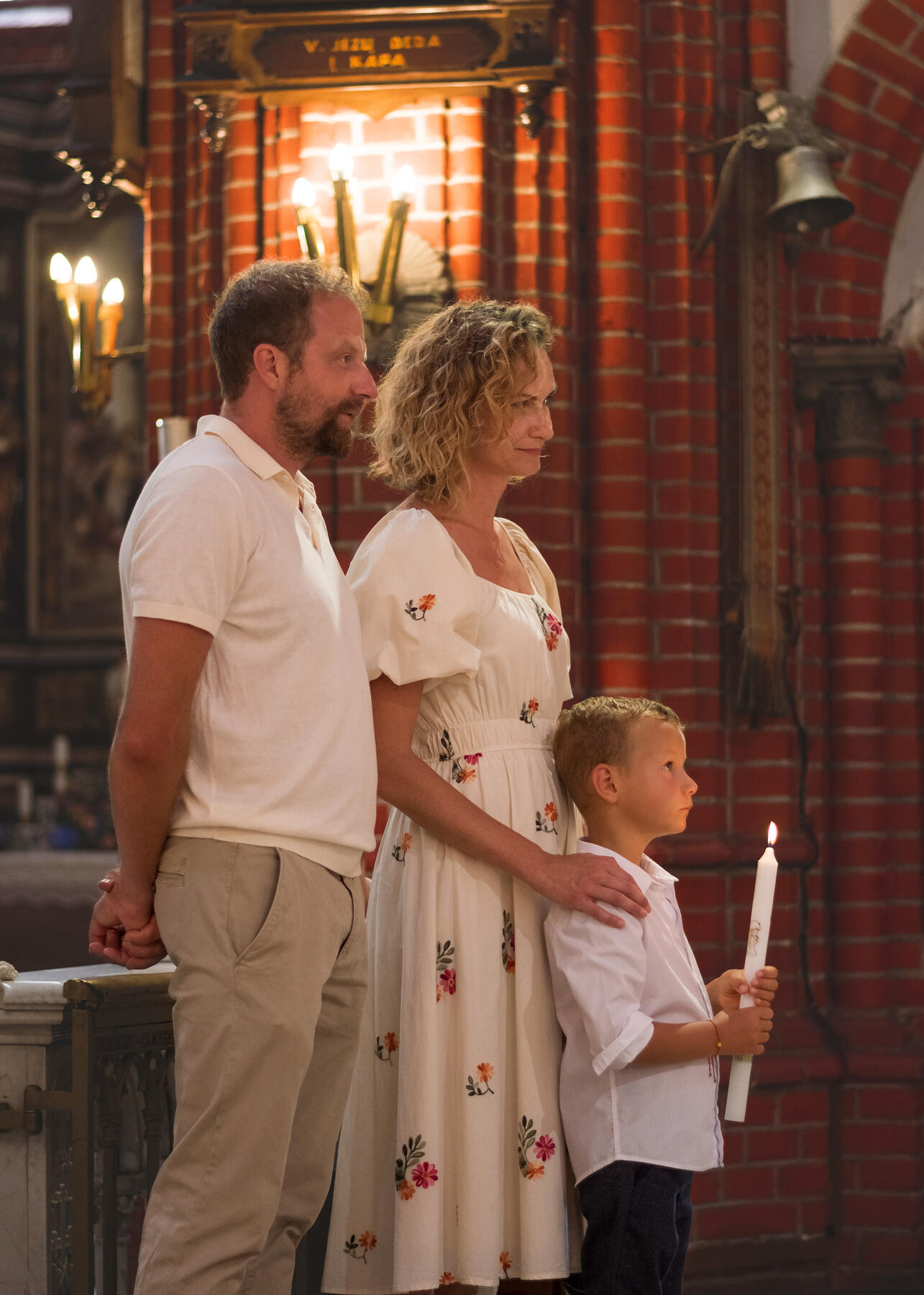 Untitled Krikštynų ceremonija, vaikas laiko degančią žvakę