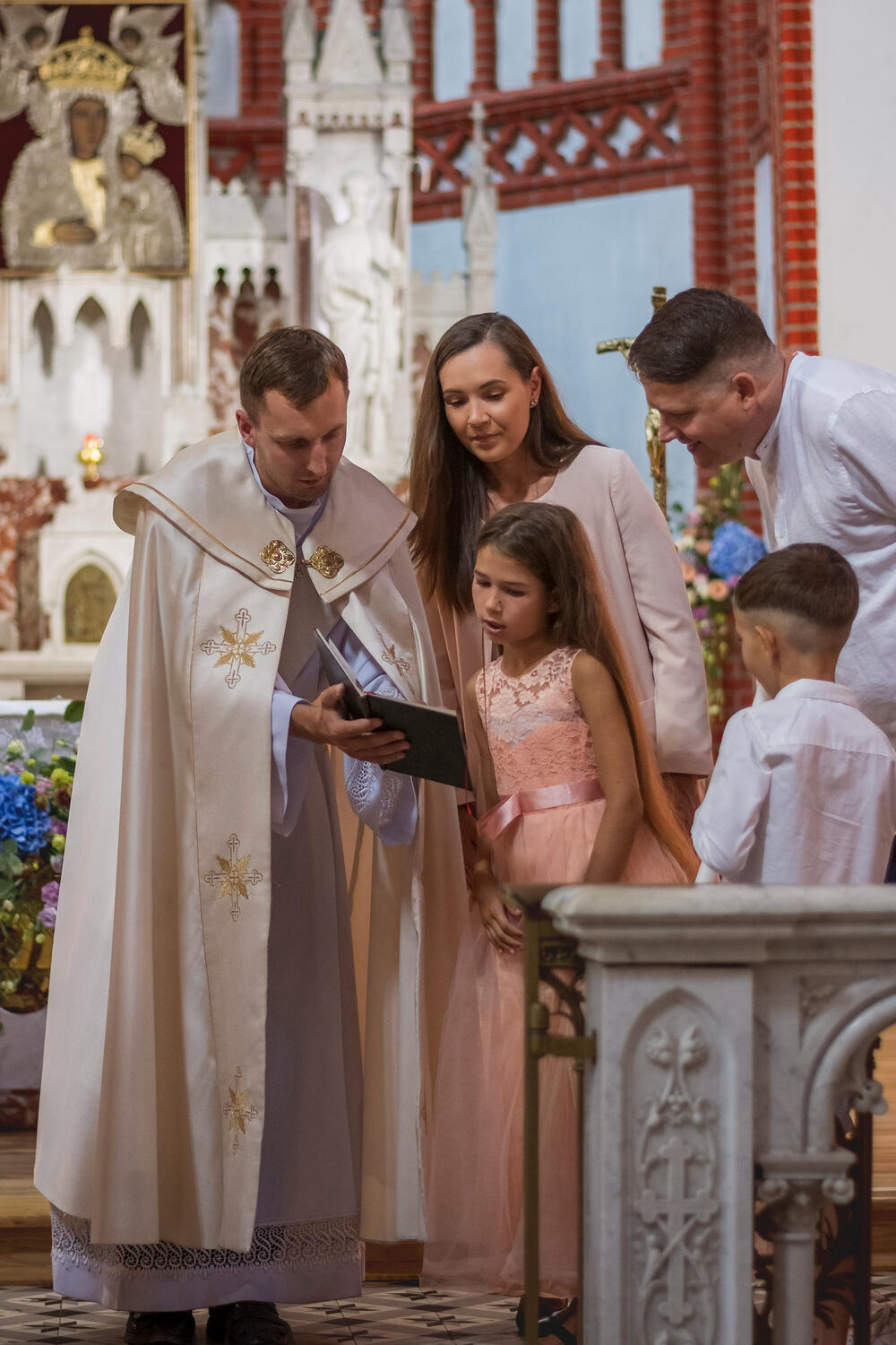 Krikštynų fotosesija Kunigas, vaikai ir jų tėvai skaito iš šventos knygos