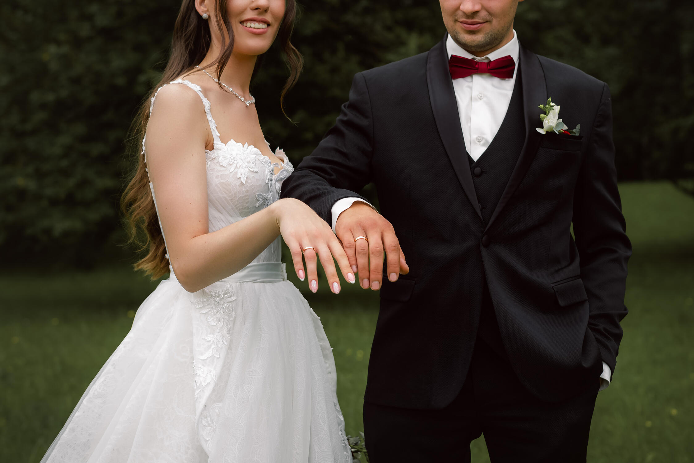 Vestuvinė fotosesija Jaunikis ir jaunoji rodo savo žiedus, vestuvinės detalės