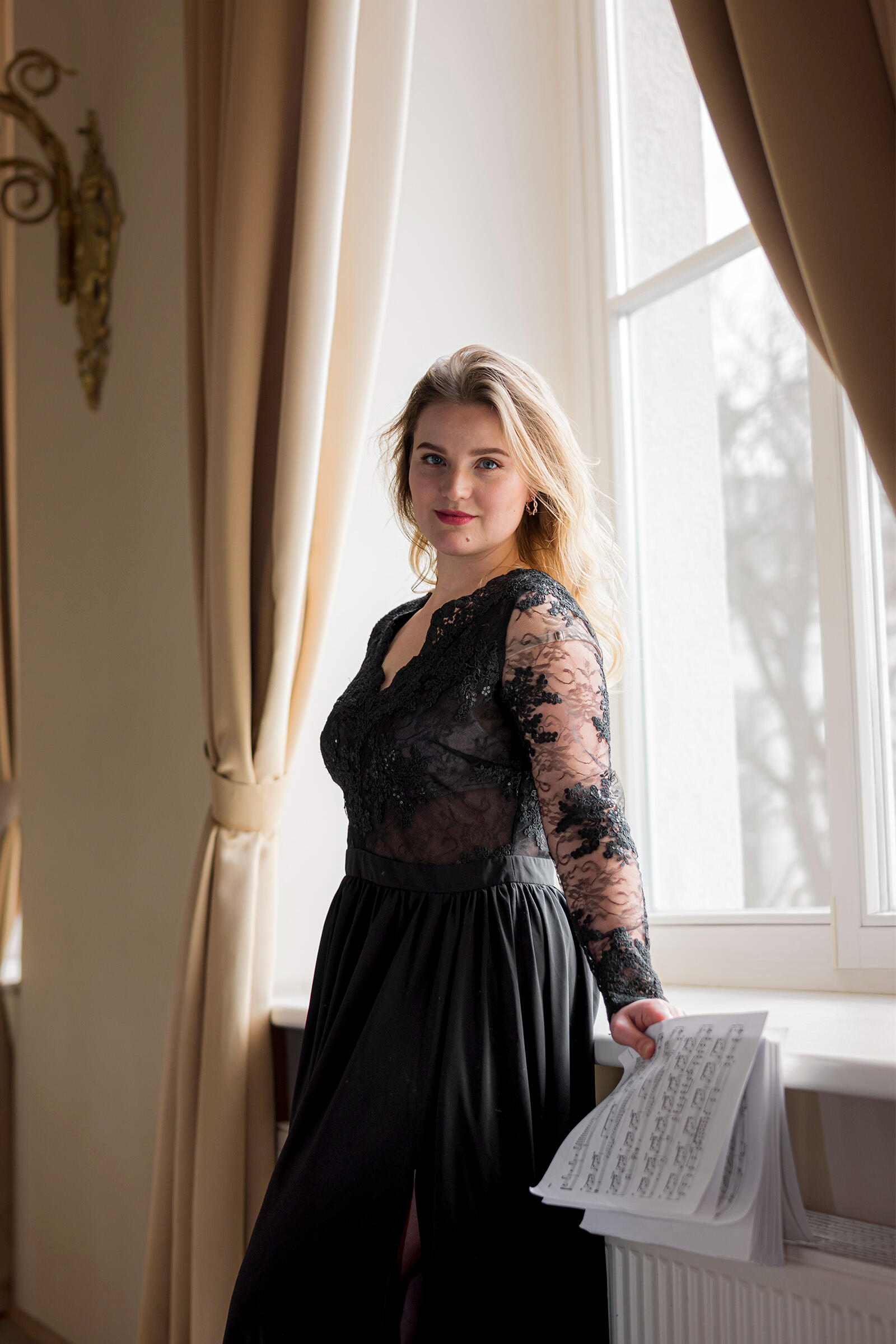 Pianistės asmeninė fotosesija Muzikantė pozuoja su natomis rankoje. Vidutinio plano kadras