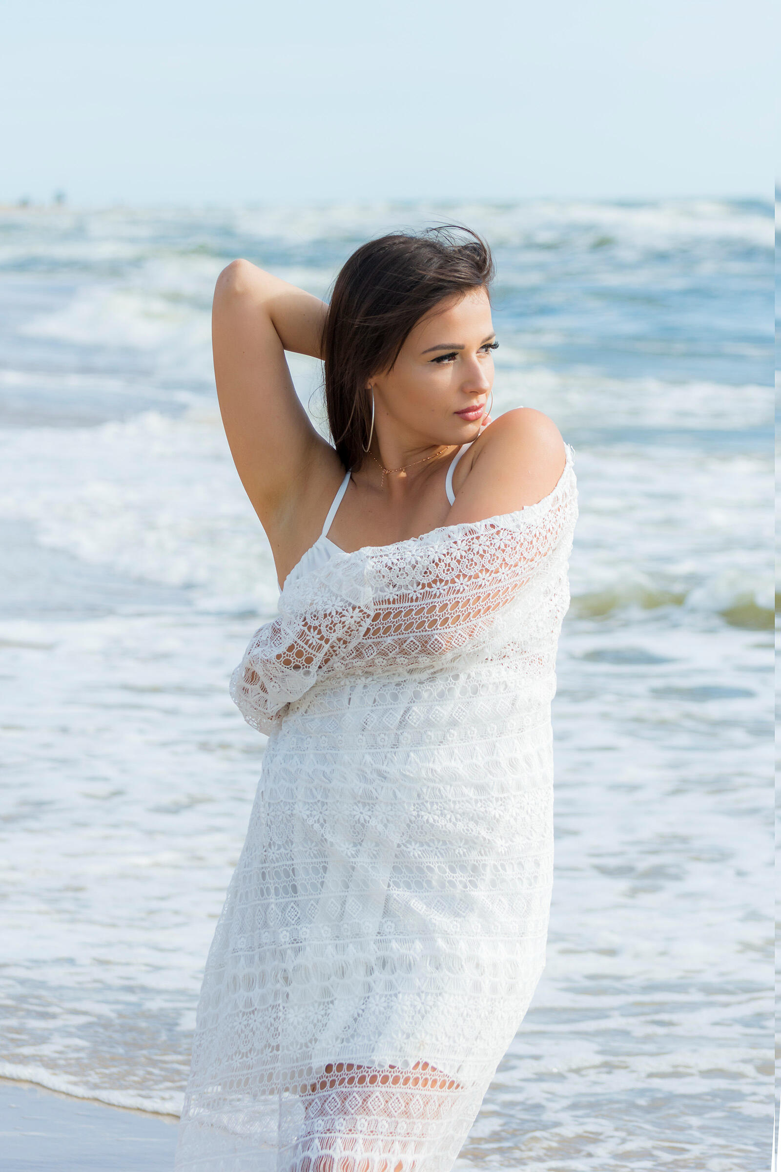 Mergina prie jūros pozuoja asmeninei fotosesijai